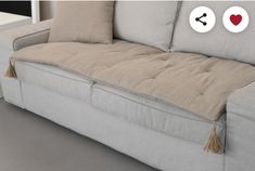 a couch with two pillows on it and one has hearts in the back, while the other loveseat is empty