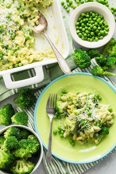 broccoli and peas are on a green plate next to a casserole dish