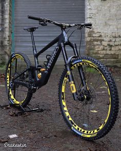 a bike parked in front of a building with graffiti on it's rims