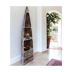 an old wooden boat shaped shelf in the corner of a room with a potted plant