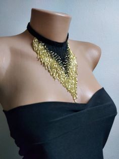 a mannequin wearing a black and gold beaded choker on top of a dummy