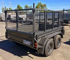 a black trailer with caged in animals on the back