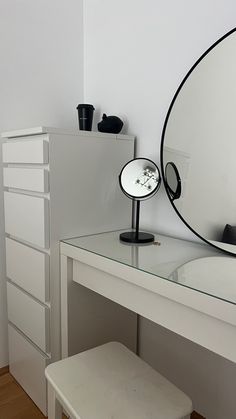 a white desk with a mirror and stool