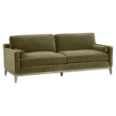 an olive green velvet sofa with wooden legs