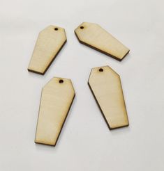 four wooden tags are shown on a white surface