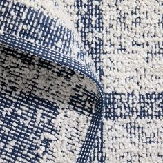 an up close shot of a blue and white rug with small squares on the side