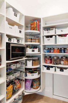 an organized pantry with white shelving and lots of food in bins on the shelves