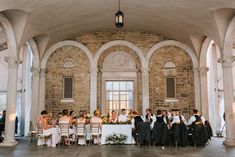 a group of people sitting at a table in a room with arches on the ceiling