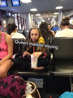 a woman sitting on top of an airport bench