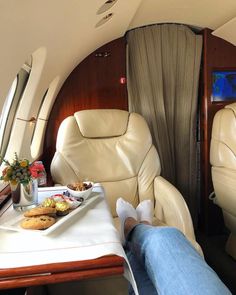 the interior of an airplane with food and drinks on the table in front of it