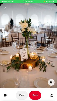 a centerpiece with flowers and candles is displayed on a table at a wedding reception