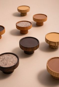 several wooden bowls with different types of food in them on a white surface, including one containing rice and the other containing powder