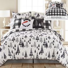 a bed covered in black and white christmas themed comforter sets with trees on them