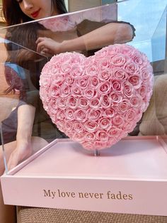 a pink heart shaped box with roses in the shape of a human hand and saying, my love never fadess