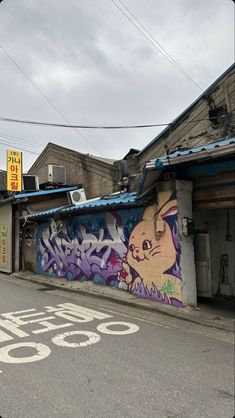 an empty street with graffiti on the wall