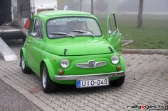 an old green car is parked on the street