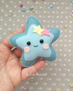 a hand holding a small blue star brooch