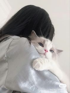 a woman holding a white cat in her arms