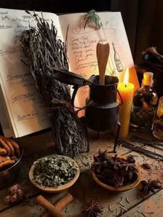 an open book sitting on top of a wooden table next to bowls filled with herbs