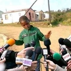 a group of people standing around microphones and talking to someone in front of them