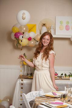 a woman standing in front of a table with balloons