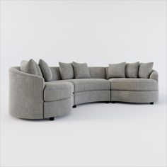 a curved sectional sofa with pillows on the back and sides, in grey fabric against a white background