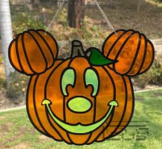 a stained glass mickey mouse pumpkin hanging from a chain