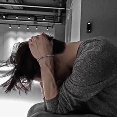 a woman sitting on the floor with her head in her hands