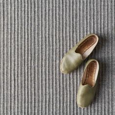 two pairs of shoes sitting on top of a carpet