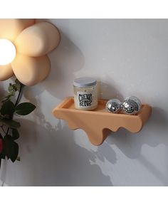 a candle and some silver balls on a shelf