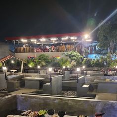 a table with food and drinks on it in front of an outdoor restaurant at night