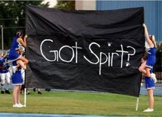 some cheerleaders are doing tricks on a banner