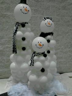 three snowmen made out of balloons sitting on top of a table