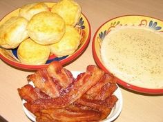 three bowls filled with different types of food on top of a wooden table next to a bowl of dip