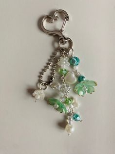 a close up of a key chain on a white surface with beads and charms attached to it