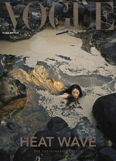 a magazine cover with a woman laying on the ground in water and rocks around her