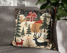 a couch with a pillow on it and a house in the woods next to it