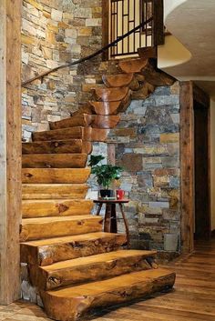 a wooden stair case next to a stone wall