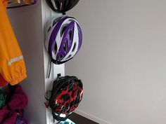 three helmets are hanging up on the wall