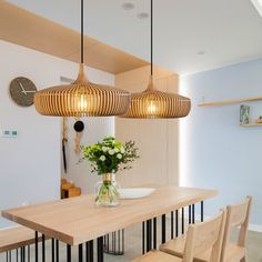 a wooden table and chairs in a room with lights hanging from it's ceiling