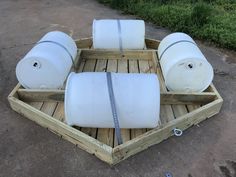 four white barrels sitting on top of a wooden crate