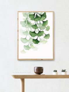 a painting hanging on the wall above a table with potted plants in front of it