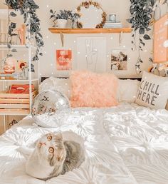 a cat laying on top of a bed in a room with pink and white decor