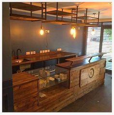 an empty bar with wooden counter tops and lights hanging from the rafters above it