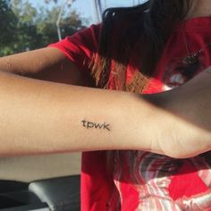 a woman with a tattoo on her arm that says fdwk in black ink