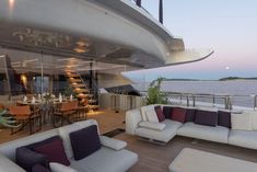 the interior of a boat with couches, tables and chairs on it's deck