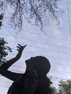 a woman reaching up into the air to catch a frisbee in her hand