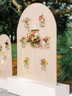 an outdoor seating area with flowers on the wall and numbers in vases attached to it