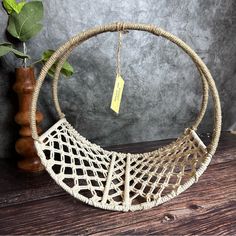 a woven hammock hanging on a wooden table next to a potted plant