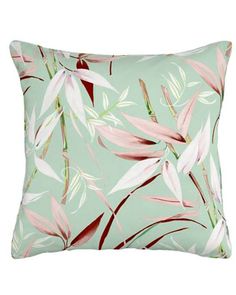 a green pillow with pink and white flowers on the front, along with red leaves